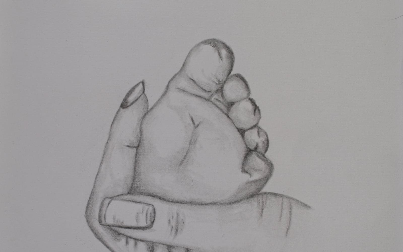 A pencil drawing of an infant's foot held in an adult hand