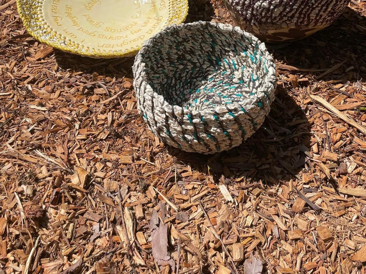 Three coiled bowls grouped on garden mulch