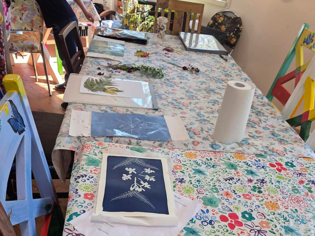 A long table laid out with cyanotype prints in progress