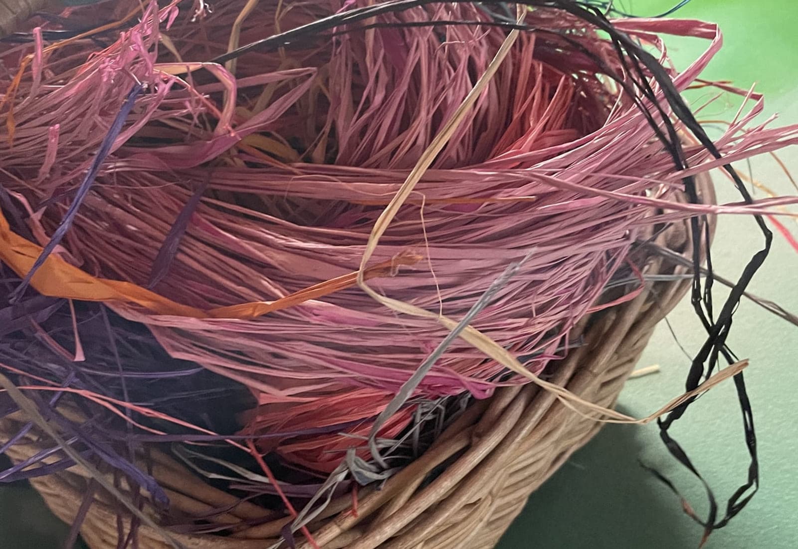 A basket of pink and red dyed raffia
